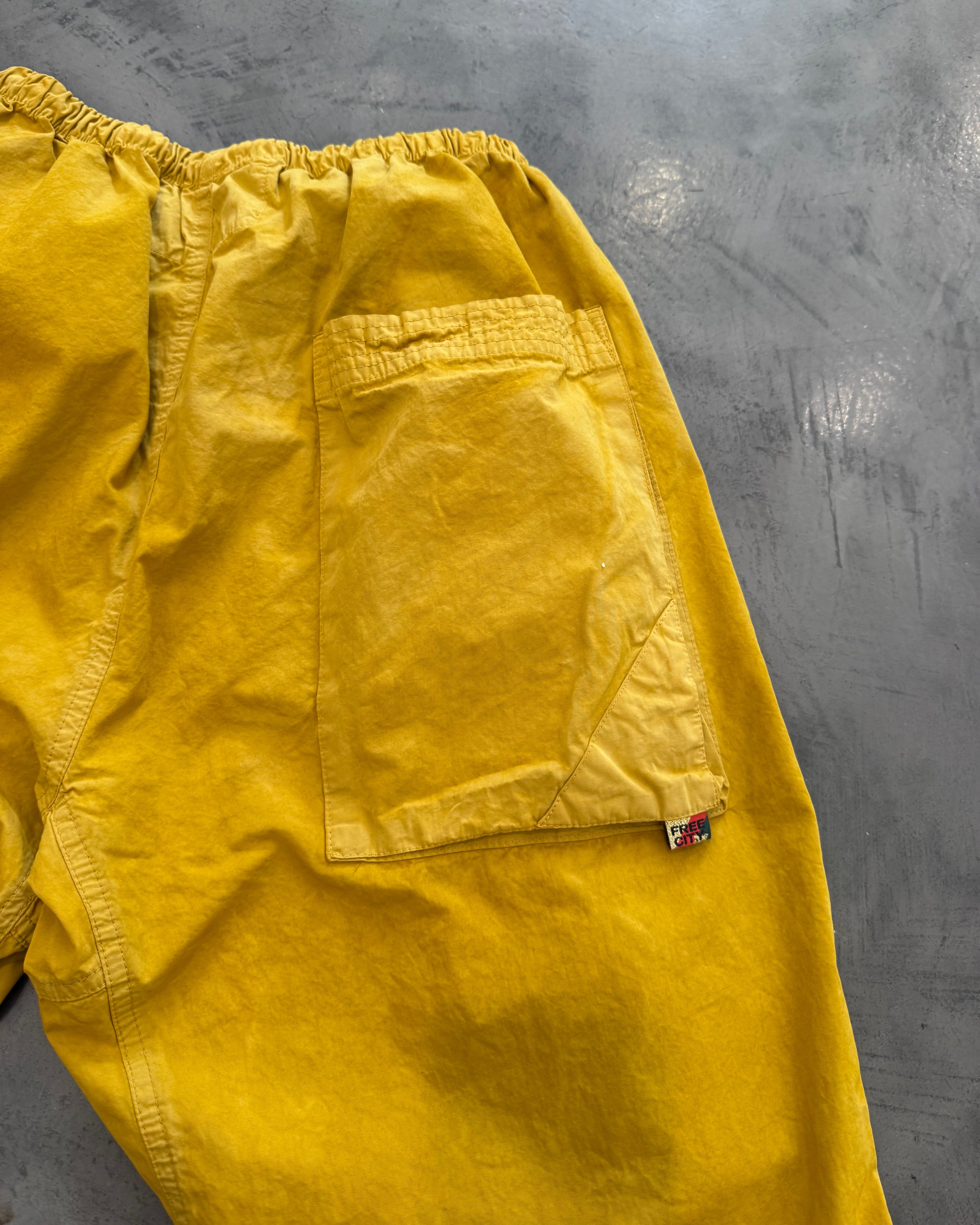 Yellow pants with a pocket on a gray surface