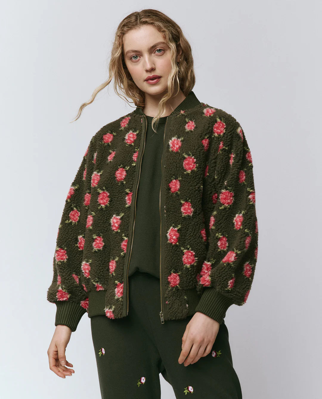 Woman wearing a floral patterned jacket on a plain background