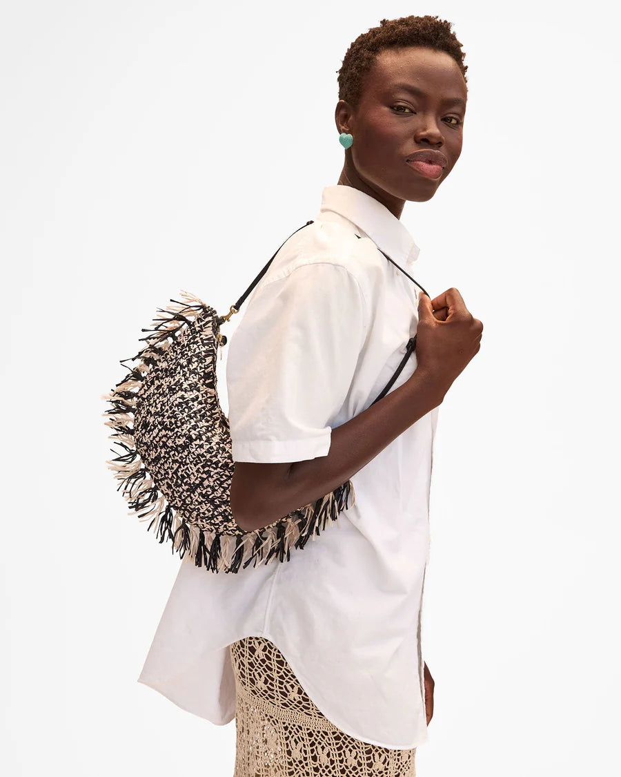 Woman holding a textured black and white bag against a white background