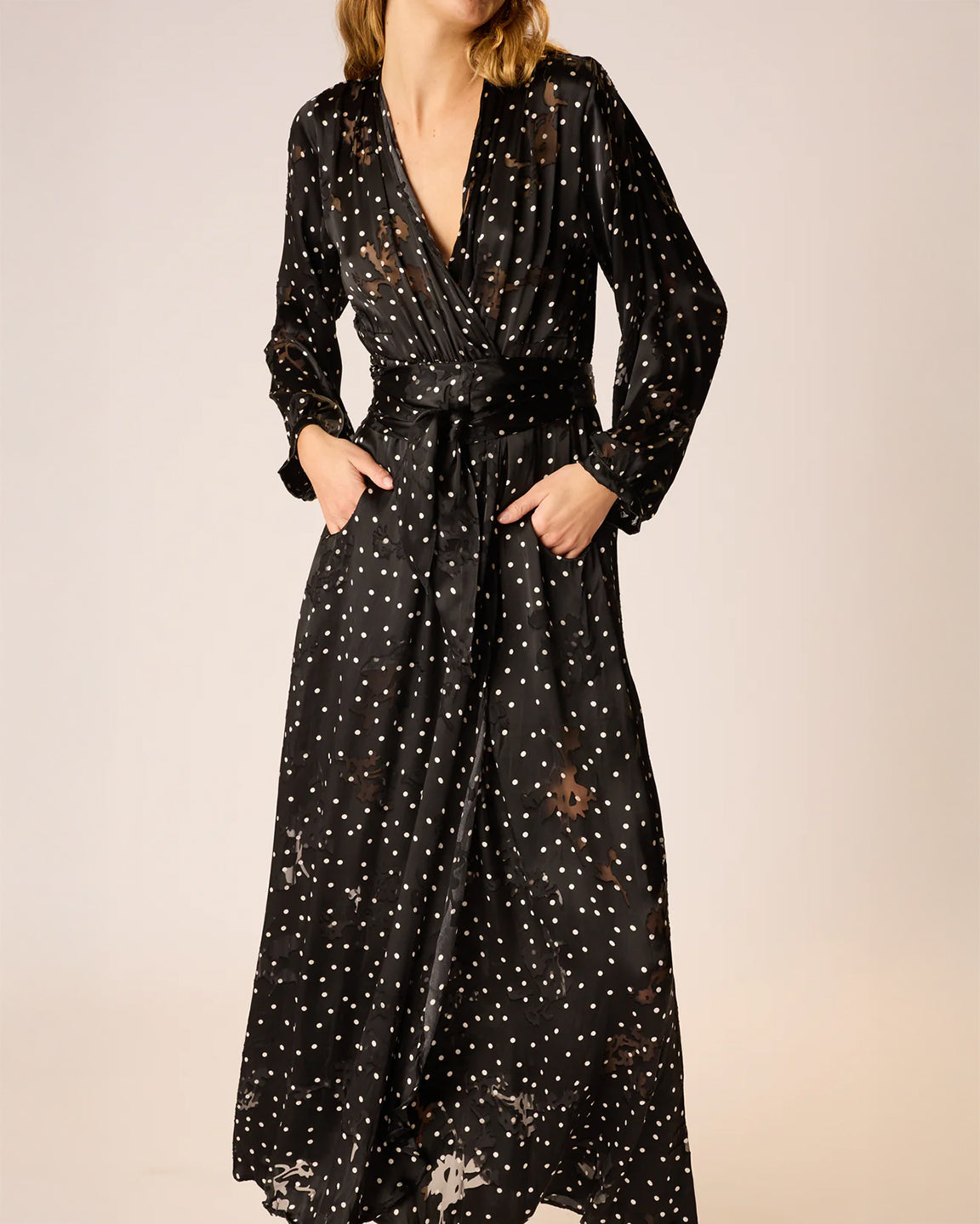 Black dress with white star pattern worn by a person on a beige background
