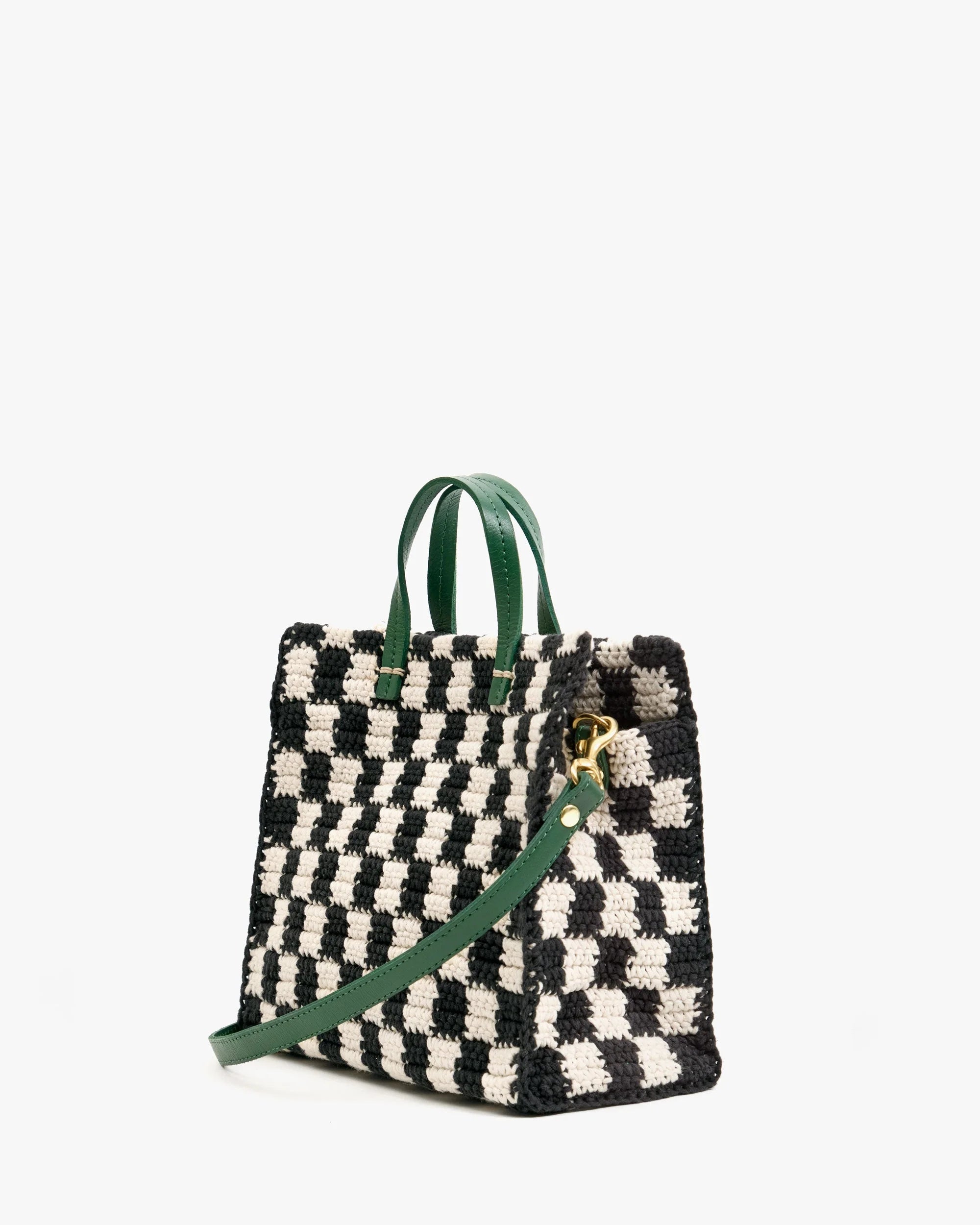 Black and white checkered bag with green handles on a white background