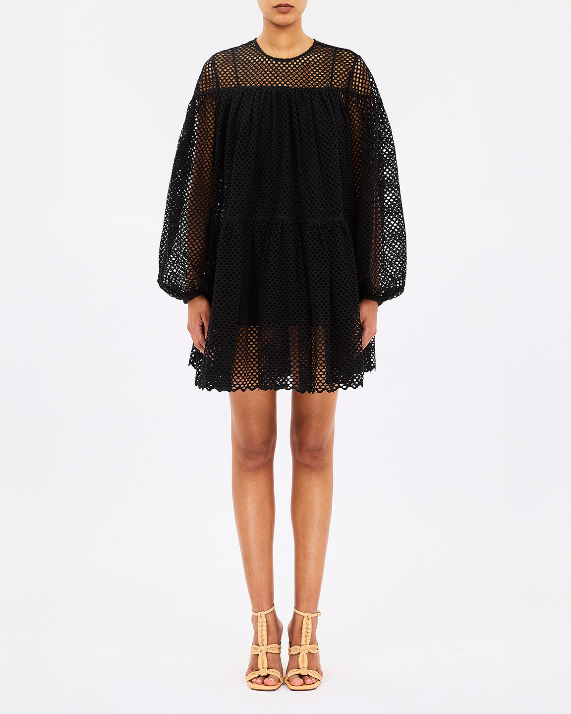 Black lace dress worn by a model on a white background