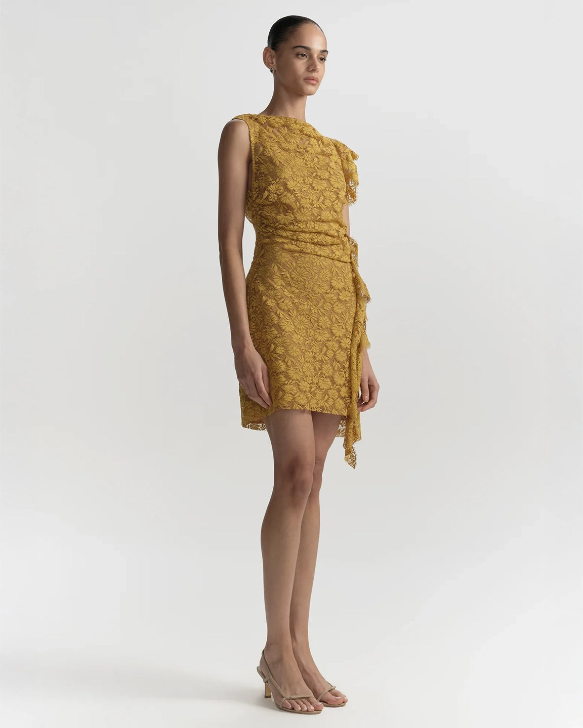 Woman wearing a mustard yellow dress against a white background