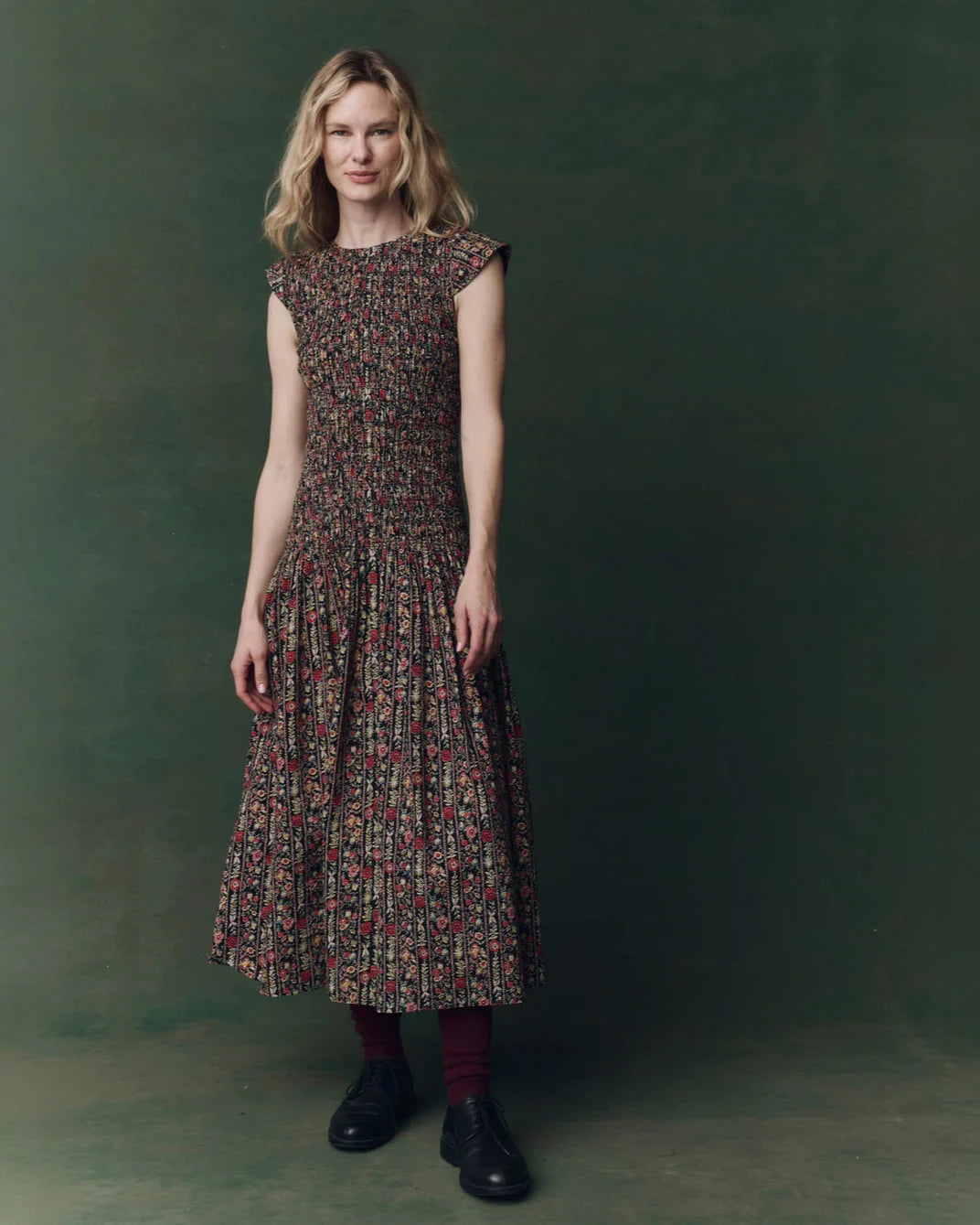 Woman wearing a floral dress against a green background