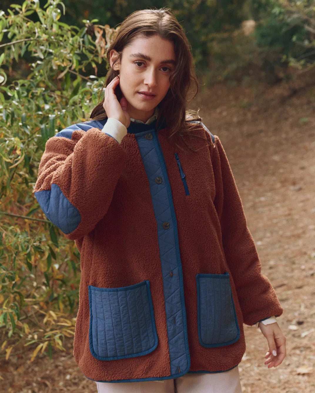 Woman wearing a brown and blue jacket outdoors