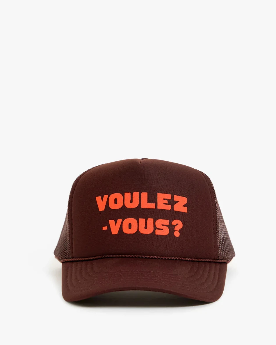 A dark brown trucker hat with orange embroidered text reading 'VOULEZ -VOUS?' on the front, set against a plain white background.