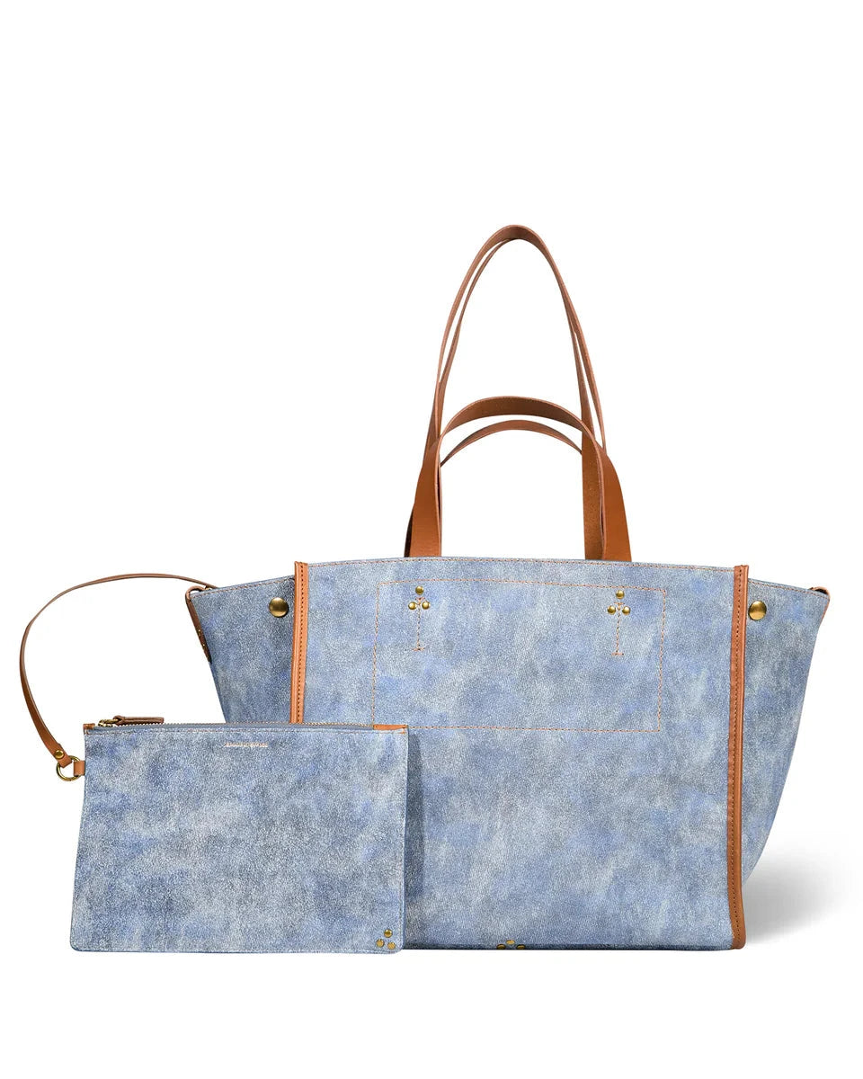 Blue tote bag with brown handles and trim on a white background