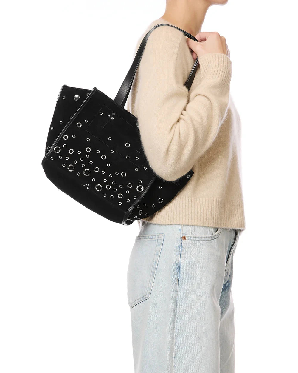 Person holding a black studded handbag with a plain background