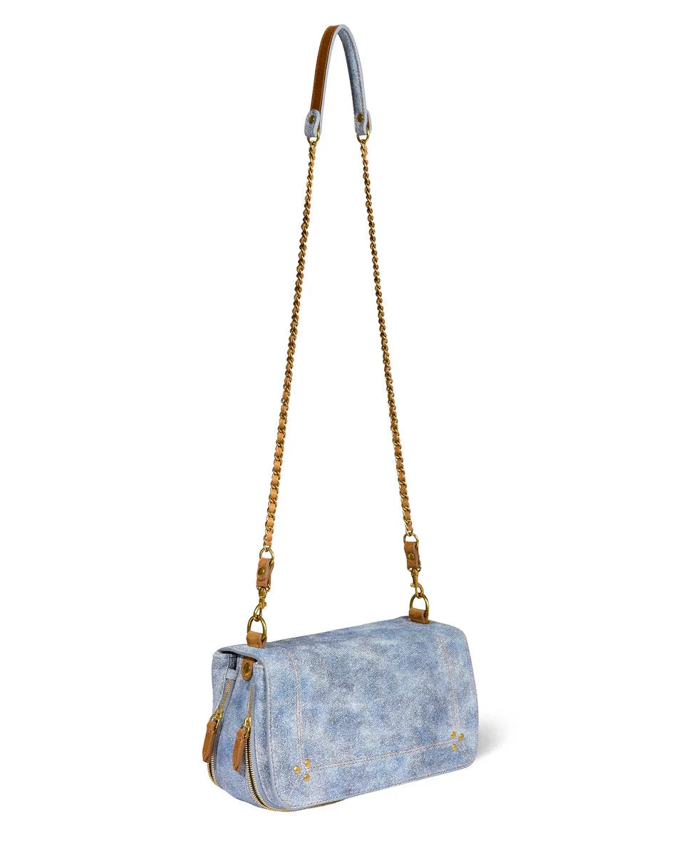 Blue denim handbag with gold chain strap on a white background