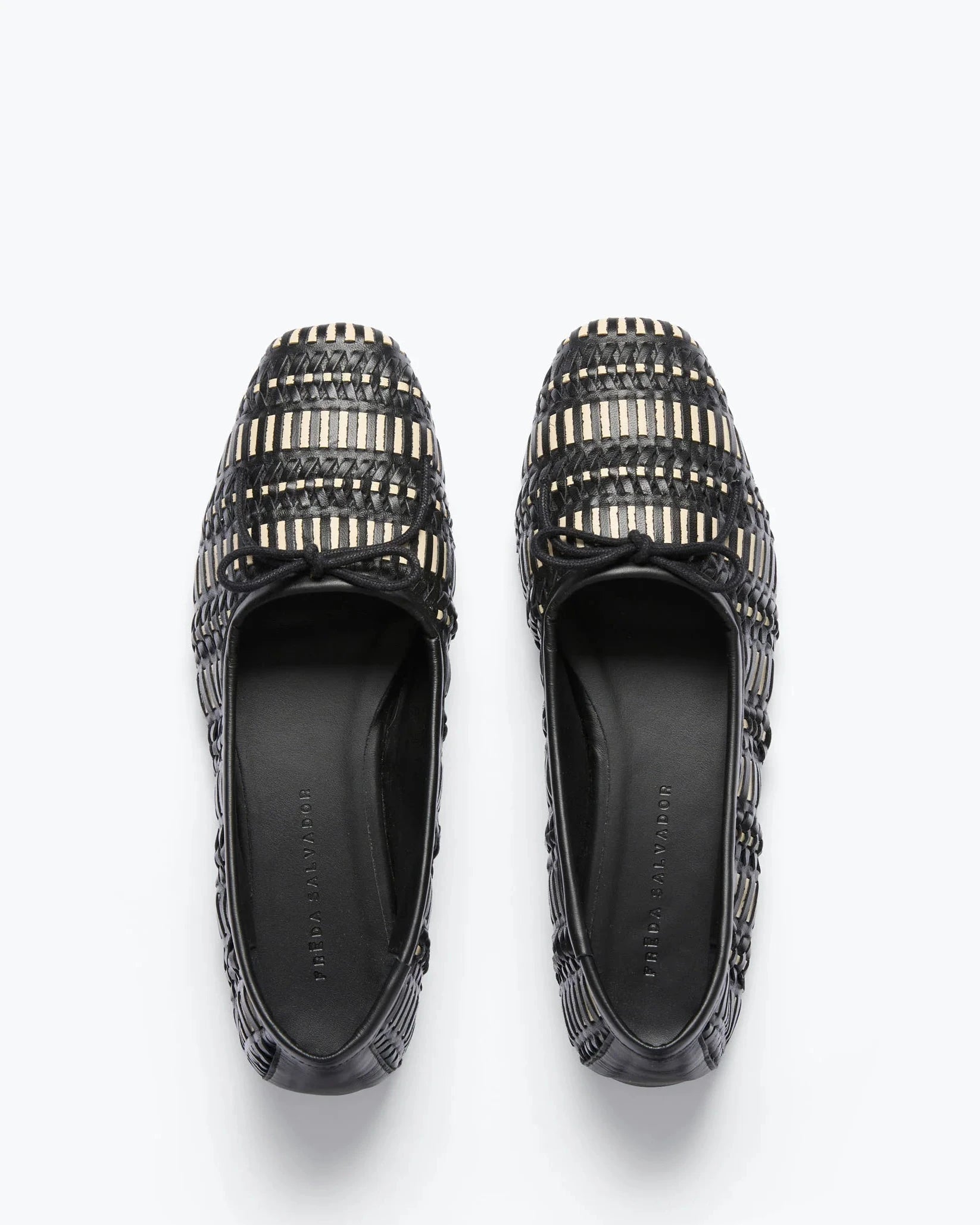 Pair of black loafers with metallic embellishments on a white background