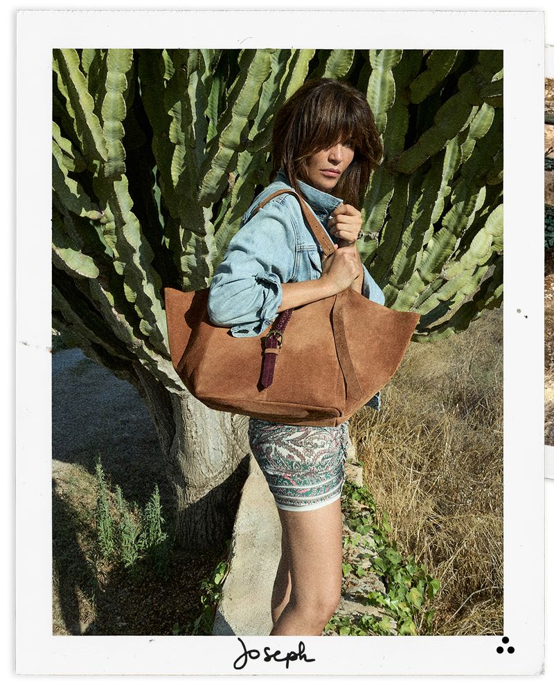 Woman holding a brown leather bag in front of cacti, with 'Joseph' branding.