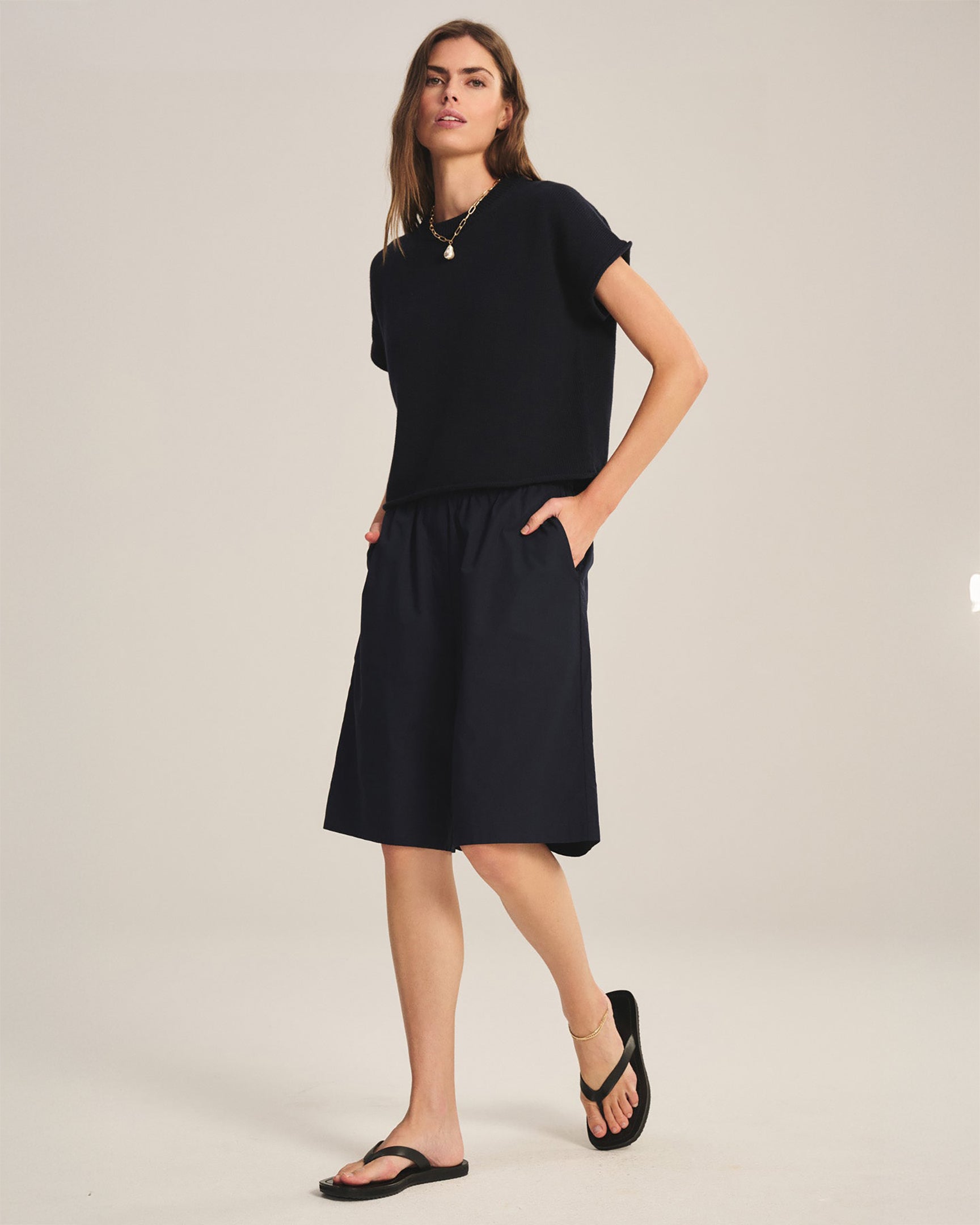 Woman wearing a black dress on a plain background