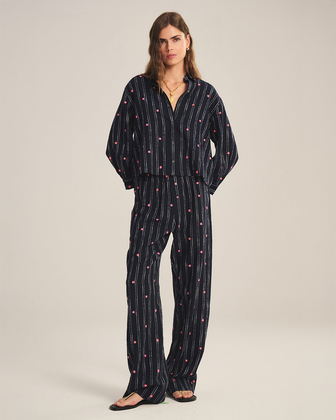 Woman wearing a black patterned outfit on a plain background