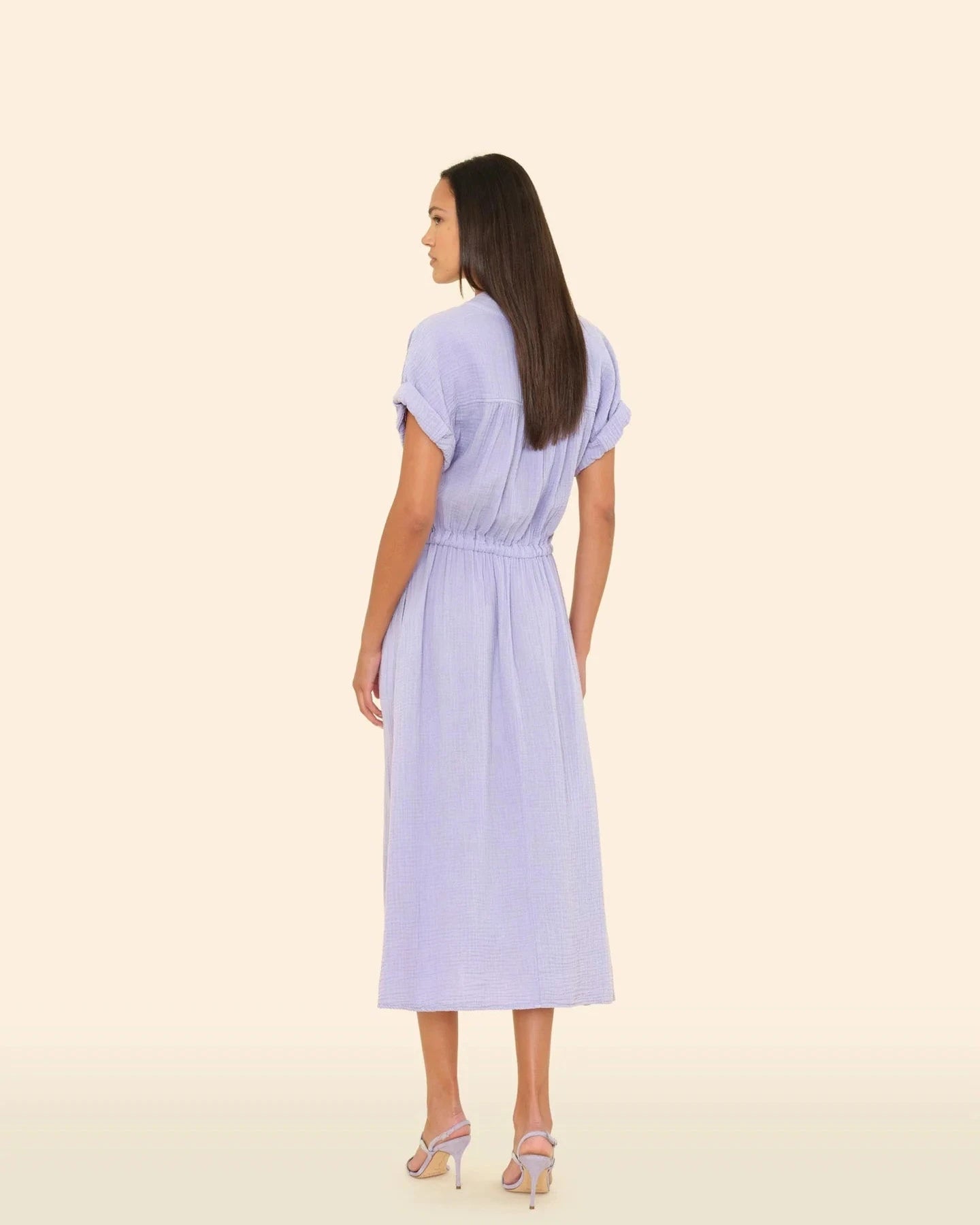 Woman wearing a light blue dress on a beige background