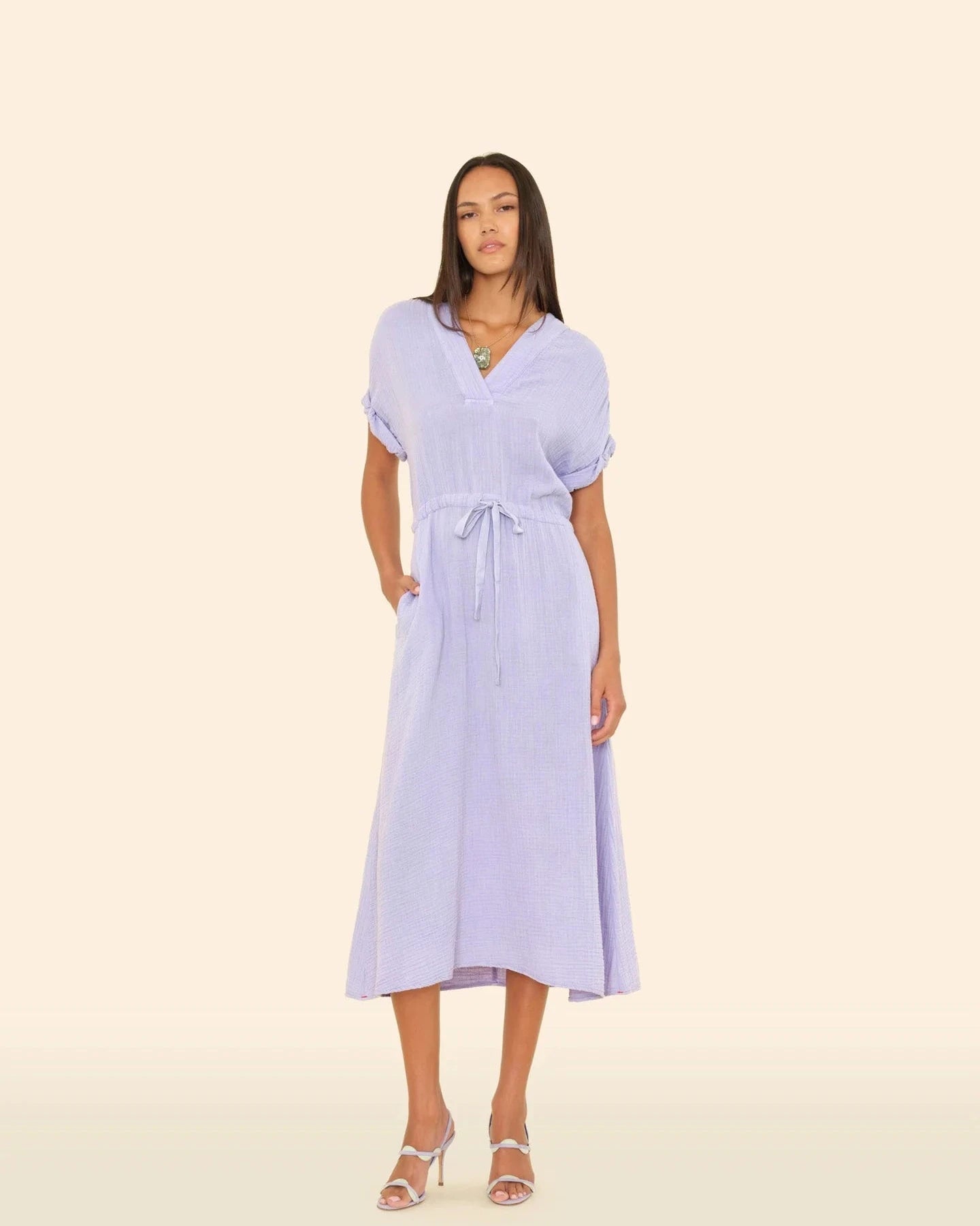 Woman wearing a light purple dress on a beige background