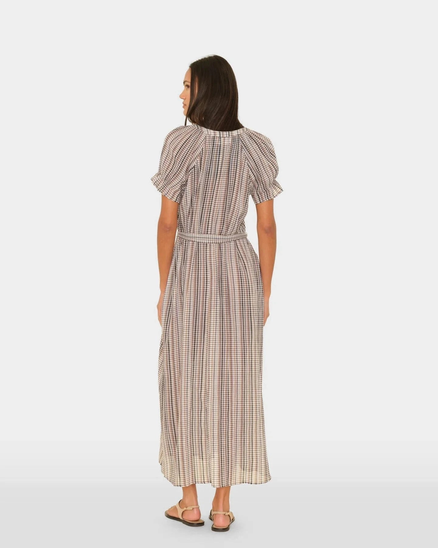 Woman wearing a checkered dress on a white background