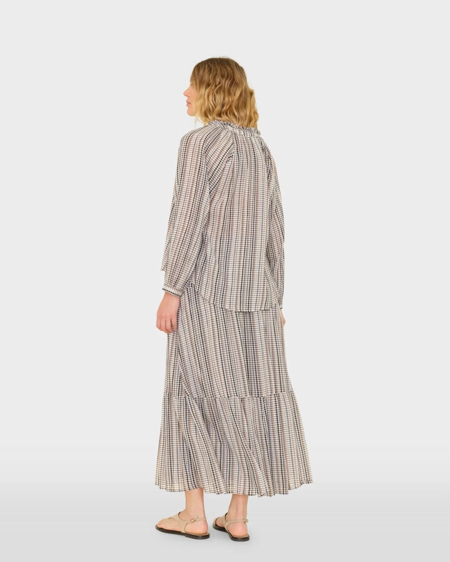 Woman wearing a checkered dress on a white background