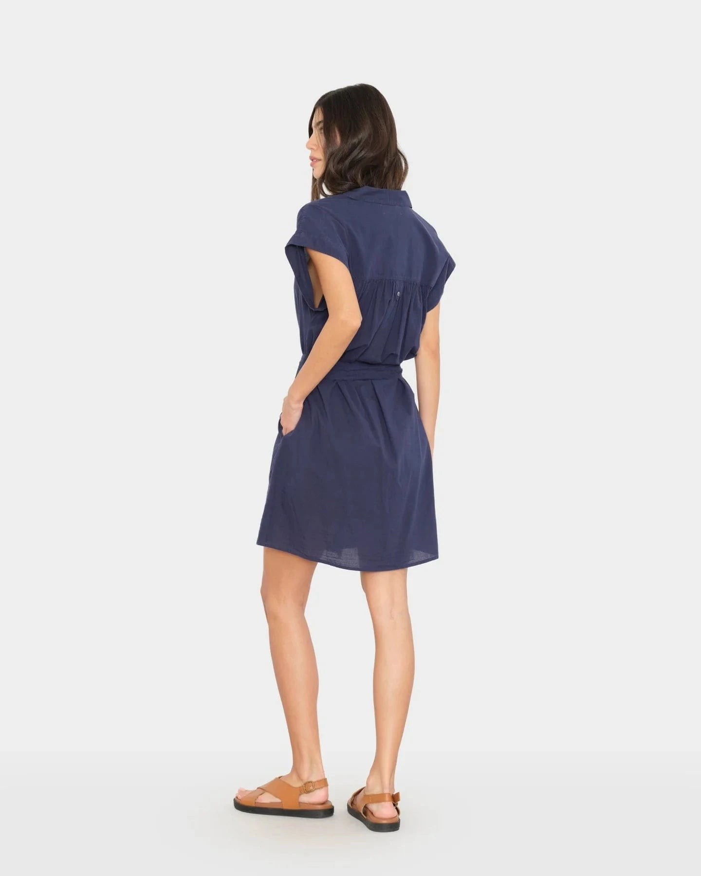 Woman wearing a navy blue dress on a white background