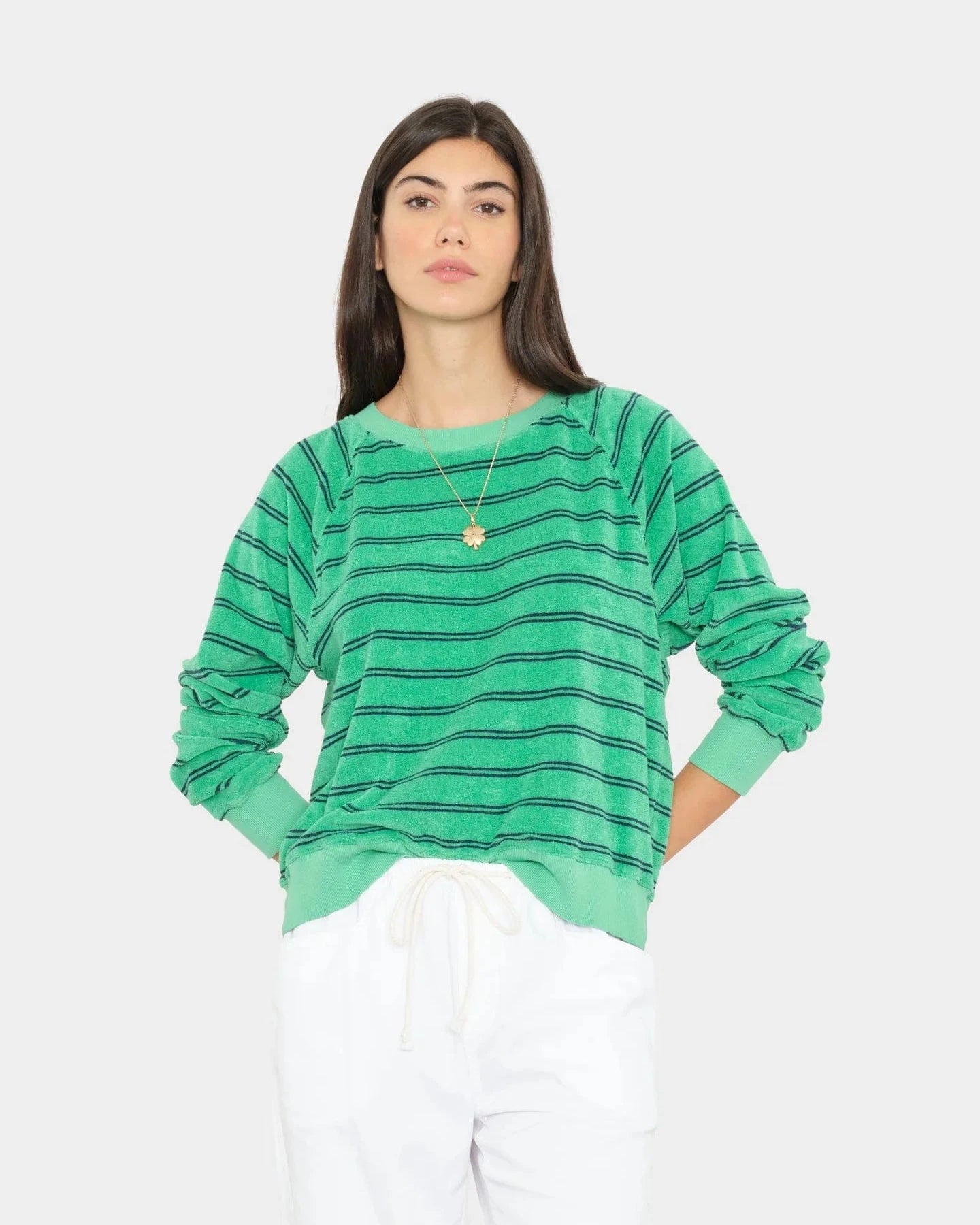 Woman wearing a green striped sweater on a white background