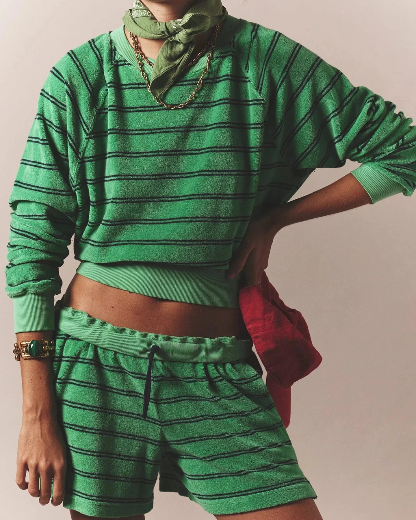 Person wearing a green striped outfit with a matching headscarf against a neutral background