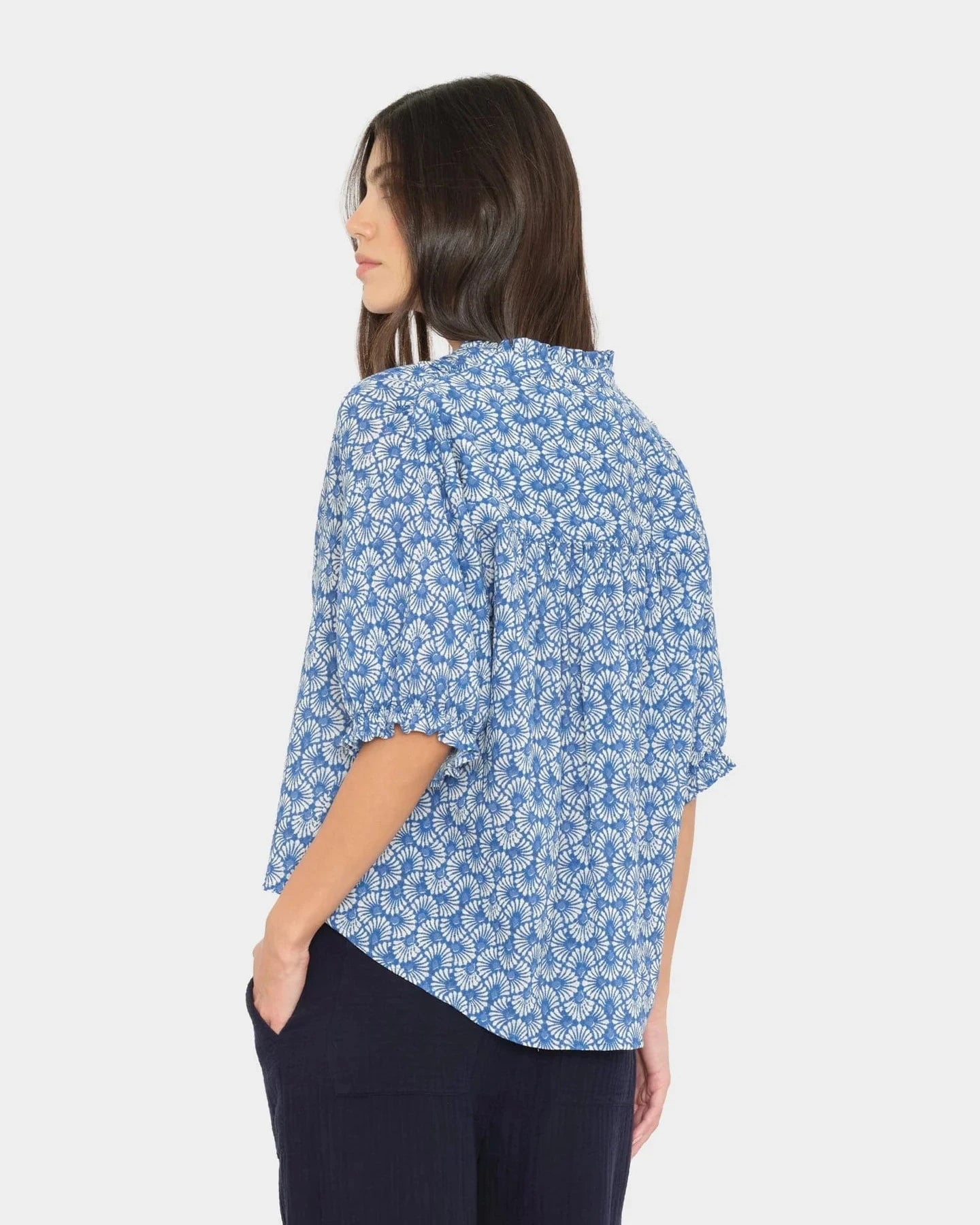 Woman wearing a blue floral patterned shirt on a white background